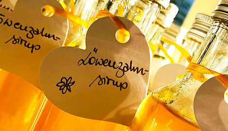 Bottles of dandelion syrup with handwritten heart-shaped labels