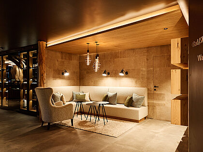 Cozy seating area with armchair, sofa and modern lighting in a warm wooden interior